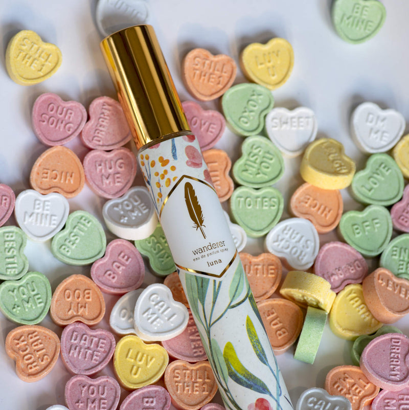 Luna Travel size spray in a botanical print over some heart shaped sweets