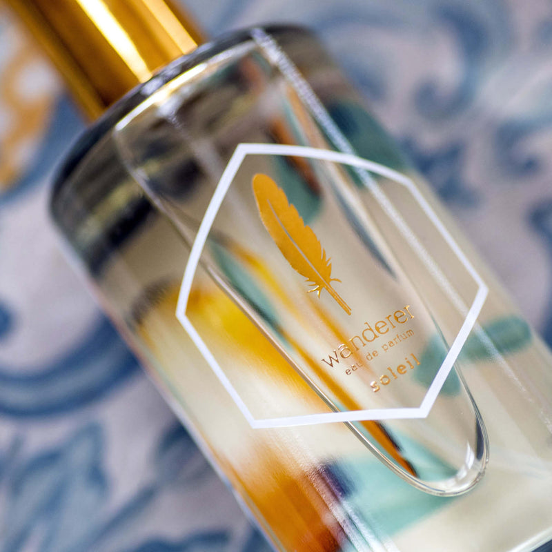 Soleil eau de parfum in a clear bottle with a botanical print
