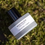 Country Cabin eau de parfum in grey bottle in the woods