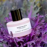 Sunday Afternoon pink bottle over a purple leaves plant